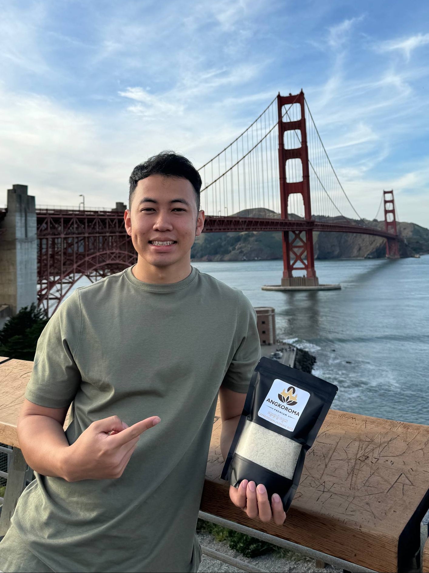 Person holding a product with a bridge and water in the background
